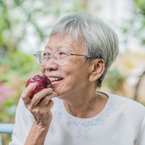 Older adult eating apple