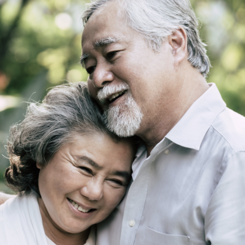older adult asian couple hugging